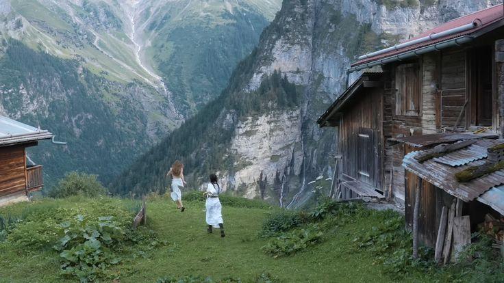 Two people doing handstands on a lush mountain field, symbolizing energy and vitality. Highlights topics of bovine colostrum for weight loss and whether it causes weight gain.